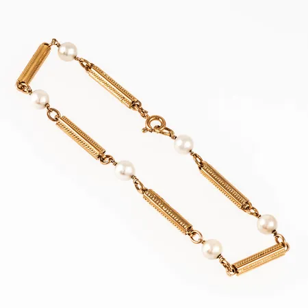 Stavarmband i 18K guld med sex odlade pärlor Ø 5,2 mm. Det är 20 cm långt, 3,3 - 5,2 mm brett och väger 8,6g. Stavarnas längd 15 mm. Stämplat ESM (Svedboms i Vetlanda) 18K & kattfot. Springring.