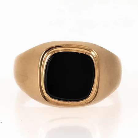 Klackring i 18K guld med svart sten. Den är i storlek 19¾, är 3,2 - 12,6 mm bred och väger 3,5g. Tillverkad 1969 av Ceson i Göteborg. Stämplat 18K & kattfot.