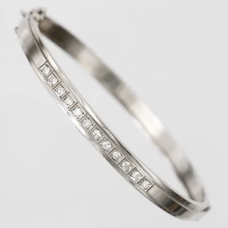 Armring med diamanter 12 x ca 0,03ct enligt gravyr, öppningsbar, innermått: 53 x 62 mm, bredd: 5,5 mm, Ceson Guldvaruaktiebolag, Göteborg år 1976, 18K vitguld. Vikt: 15,2 g