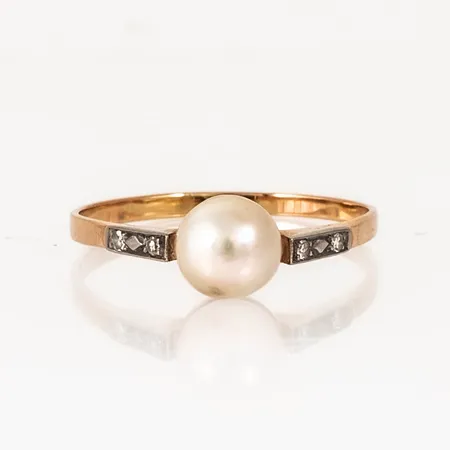Ring i 18K guld med odlad saltvattenpärla Ø 6,5 mm och 4 x 0,01ct 8/8 slipade diamanter. Den är i storlek 19, är 1,6 - 6,5 mm bred och väger 1,8g. Stenstorlek 0,04ct ingraverad. 