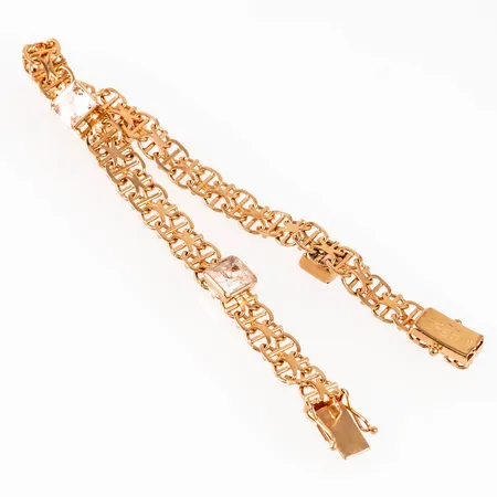 Armband, X-länk med stav i 18K guld med fyra vita stenar 6,5 x 6,5 mm. Det är 19 cm långt, 6,5 mm brett och väger 12,2g. Kistlås. Stämplad 18K & kattfot. 