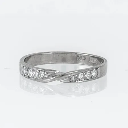 Ring i 18K vitguld med 4 x c:a 0,03ct, 2 x c:a 0,025ct, 2 x c:a 0,01ct 8/8 slipade diamanter. Den är i storlek 17½, är 2,8 mm bred och väger 2,3g. Stenstorlek 0,19ct ingraverad. Stämplad Z9 (1974), ALTON, Falköping, 18K & kattfot. Flera sprickor i skenan.