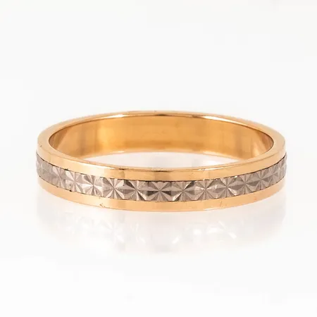 Mönstrad ring i 18K röd- och vitguld. Den är i storlek 23¼+ (Ø 73), är 4,5 mm bred och väger 6,7g. Stämplad SCH (Schalins Ringar, Östersund), 18K & kattfot.