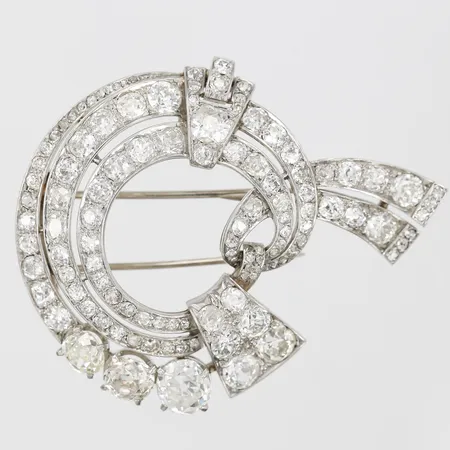 Brosch/clip Art Deco med 113st gammalslipade diamanter totalt ca 11,75ctv, kvalitet ca TW-Ca(F-M)/VS-SI, största stenen ca 1,50ct,  en sten med nagg, längd 55mm, bredd 45mm, tillverkad ca 1930-40-tal, platina samt broschdel i 14K vitguld. Vikt: 22,7 g