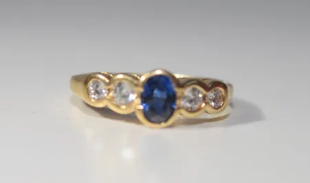 Ring med 4 diamanter 2 x 0,07 ct st + 2  0,10ct st + 1 safir, Ø 16 mm, 18k. Ringen är köpt i Australien Thoms Jewelers. ask medföljer Vikt: 3,5 g