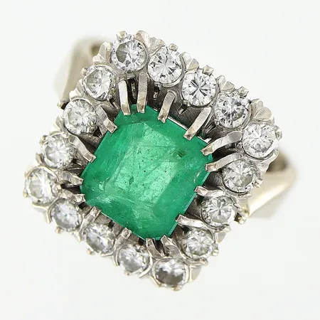 Ring, smaragd 1,32ct enligt gravyr, 16 st diamanter 0,75ctv enligt gravyr, stl 14½, bredd 2,5-14,5mm, nagg och slitage på fasetter på smaragd, något skev skena, vitguld, 18K Vikt: 6,4 g