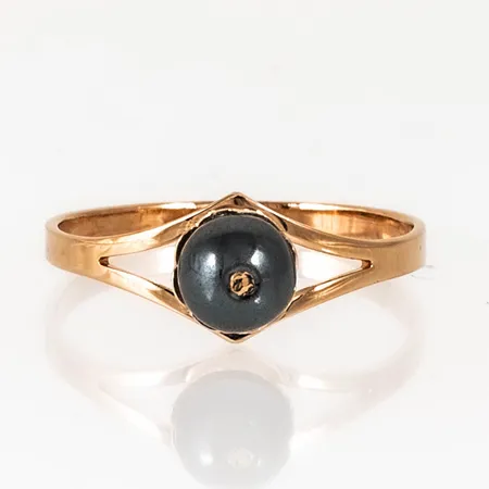 Ring i 18K guld med hematitkula. Den är i storlek 18¼, är 1,9 - 7,6 mm bred och väger 1,9g. Stämplad X10 (1996), COP, 18K & kattfot. Fint skick.