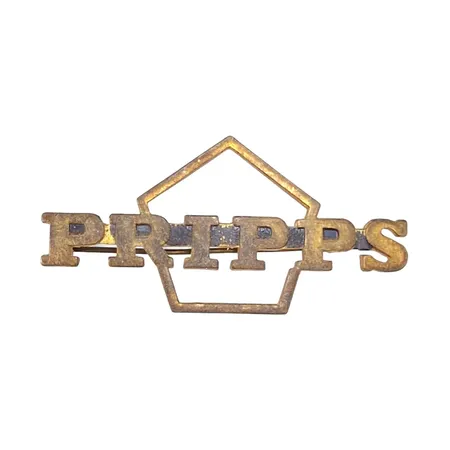 Mössmärke PRIPPS, gulmetall, längd 60 mm, höjd 30 mm, oputsat skick