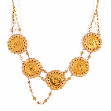 Collier i 18K guld med 5 iranska ½ Pahlavi mynt Ø 19 mm, 21,6K, vikt á 4,0g. Det är 47 cm långt, 2,5 - 28,5 mm brett och väger 33,3g. Lås karbinhake i 9K. Ojämnheter. Assymetrisk placering av kedjedekor.