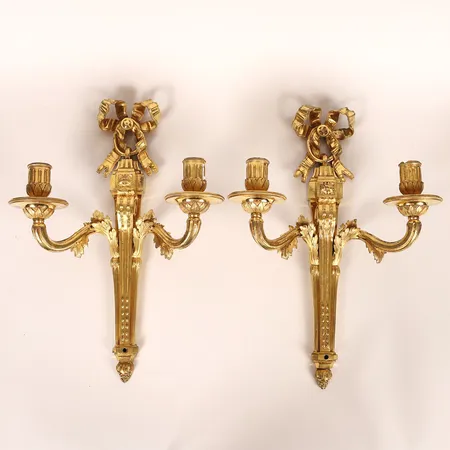 Ett par appliquer, Louis XVI-stil, 1800-tal, förgylld brons, akantusornerade ljusarmar, krönande bandrosett och avslutande druvklase, höjd 40cm, spår efter elektrifiering. Skickas med postpaket.