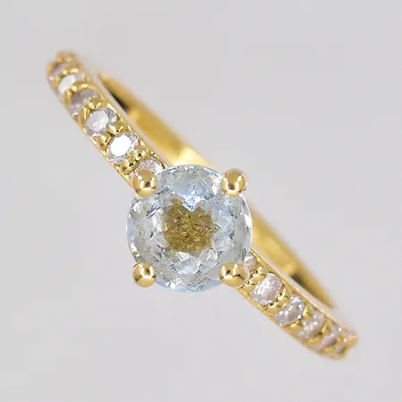 Ring, diamanter ca 14x0,02ct, stl 16¾, ljusblå sten Ø 6mm, graverad, 18K Vikt: 2,8 g