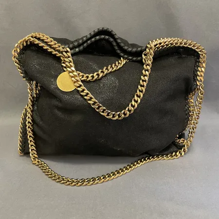 Väska Stella McCartney, Falabella, svart textil kantad med guldfärgade beslag, metallkedja, invändigt fodrad med logomönstrat tyg i rosa, mått ca 36x37cm, fläckar, bruksskick, inga tillbehör. 