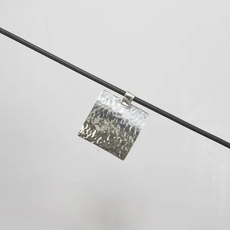 Collier, längd ca 54,5cm, bredd 3,5-43mm, plastsnöre, lås samt hänge i silver, 925/1000 silver, bruttovikt: 19,9g.