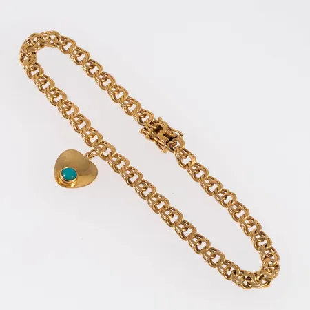 Armband, bismarck i 18K guld med en berlock. Den är 19 cm lång, 4,5 mm bred och väger 8,6g. Kistlås. 