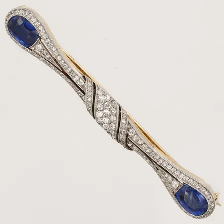 Brosch, Art Deco, med 2st obehandlade safirer ca 1,90ct samt 2,50ct, med gammalslipade, rosenslipade och antikslipade diamanter, totalt ca 2,00ct, längd 72 mm, bredd 10 mm, svenska importstämplar, med etui från David Andersen & comp. Stockholm. Vikt: 10,8 g