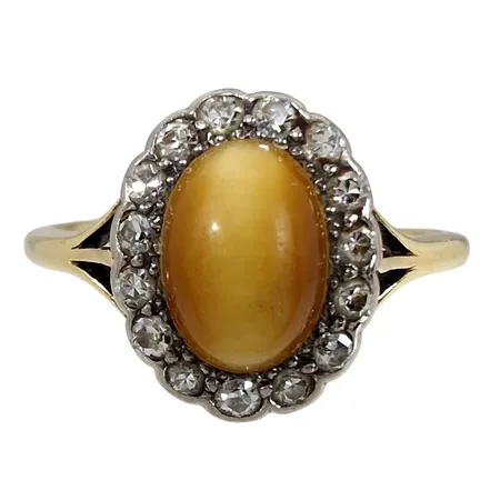 Carmoséring, 18K guld, Tigeröga 6x9 mm, Diamanter 15 x 0,015ct, Ø19¼ mm, skenans bredd 1,3 - 2 mm, frontens storlek 11x13 mm, Tigeröga med lätt ytslitage Vikt: 3,2 g