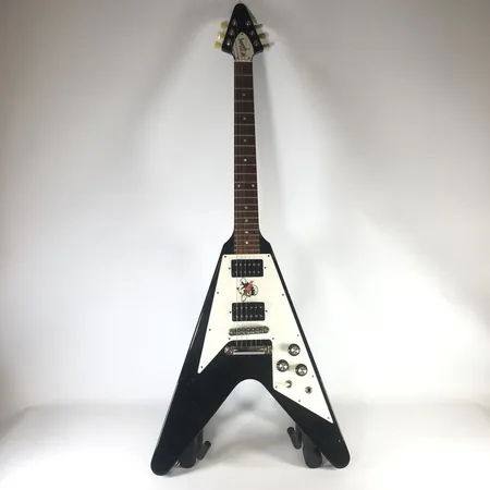 Elgitarr, Gibson Flying V, serienummer: 113920659, kraftigt slitage, stötskador, glapp i humbuckers samt eluttag, möjlig fuktskada, spricka på baksidan av kropp, skada vid hals (glapp) samt fingerbräda, hardcase med kraftigt slitage, med hardcase Vikt: 0 g Skickas med Bussgods eller PostNord