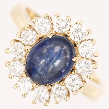 Ring med blå sten, troligtvis syntetisk blå spinell samt diamanter 12 x ca 0,08ct, stl 17¼, bredd 16mm, 18K   Vikt: 8,7 g