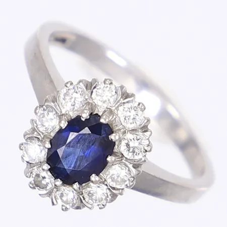 Carmoséring med diamanter totalt 0,60ctv samt blå safir 1x1,04ct enl. gravyr, stl 19, bredd 2-12mm, tillv. Juvel-Magnus AB, Henån (Göteborgs ortsmärke), vitguld 18K Vikt: 5,3 g