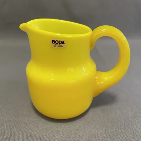 Kanna, Erik Höglund, Boda Glasbruk, höjd ca 11cm, gult glas, signerad H 1738/38, etikettmärkt, nagg vid handtag.