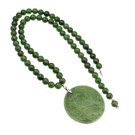 Collier med tillhörande Hänge, Jade/Nefrit, lås och detaljer i silver 925/1000, tillverkare JKa, klot Ø10 mm, längd 72 cm, hänge, större modell, graverad dekor med "Fung-huang" den kinesiska fågeln Fenix, andra sidan den kinesiska draken "Lung", diameter Ø60 mm, längd inkl. ögla i silver 68 mm, tjocklek 4 mm, fint skick utan anmärkning, vikt omkring 138 gram, originaletui (textil) medföljer, förefaller sparsamt använd Vikt: 138 g