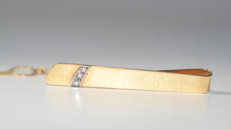 Slipshållare 70-tal med diamanter 0,08ct totalt längd 5 cm bredd 6,66 mm, 18k Vikt: 7,6 g
