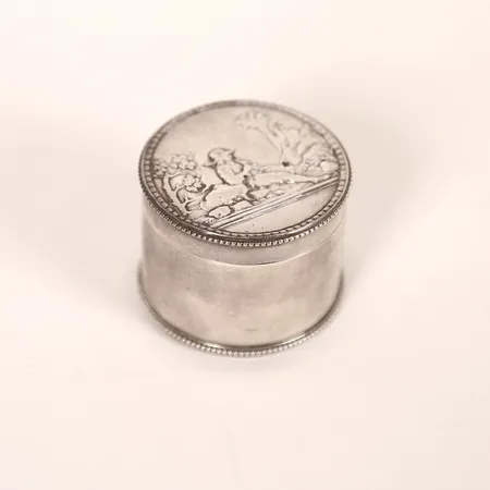 Dosa, Empire, Adolf Zethelius, Stockholm, 1811, dekor av figurscen och pärlstav, höjd 3,5cm, smärre slitage, äldre gravyr undertill, silver.  Vikt: 61,8 g