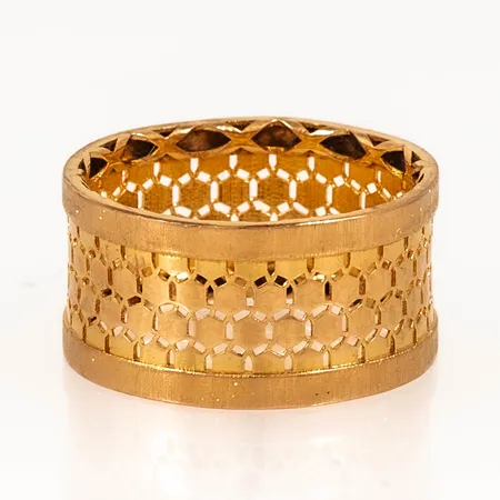 Ring i 21K guld med genombrutet mönster. Den är i storlek 19, är 11 mm bred och väger 4,7g. Stämplad 21K. Aningen ojämn skena.
