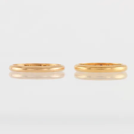 Ring med gravyr storlek 19 ½ mm, bredd 3.2 mm, 23k 6.1 gram + ring med gravyr storlek 21 mm, bredd 2.8 mm, 20k 4.2 gram. Vikt: 10,3 g