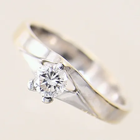 Ring med diamant ca 0,35ct, kvalitet ca Cr(J)/VS, mindre fjädrar som når ytan vid kronan, stl 16¾, bredd 4mm, vitguld, i behov av omrodiering, något otydliga stämplar, något repig skena, 18K  Vikt: 4 g
