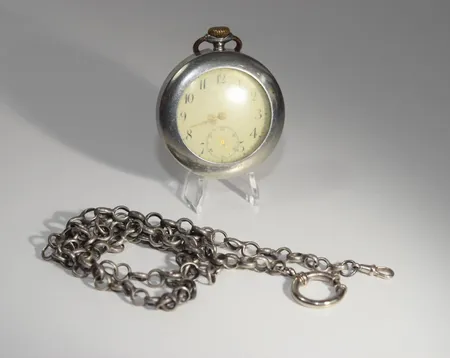 Fickur 66915 Remontoir 10 Rubis Ø 49,48 mm, kedjan är i silver men inte låset och skyddet. Uret går ej. Total vikt 138,4 gr. Vi lämnar ingen funktionsgaranti Vikt: 0 g