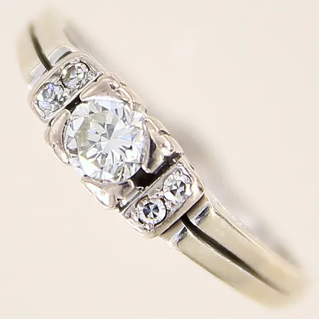 Ring med diamanter 1 x ca 0,30ct, kvalitet ca Top Cape(K)/VS, 4 x ca 0,01ct, stl 17¾, bredd 1,5-5mm, svensk importstämpel, i behov av omrodiering, 18K  Vikt: 3,8 g