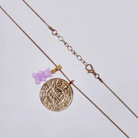 Kedja längd ca 59-63cm, bredd ca 1mm, 1 hänge med detalj i plast längd ca 25mm, 1 hänge Ø 30mm