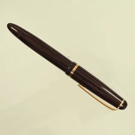 Reservoarpenna Montblanc 342 i rödbrun färg, längd 12cm, spets 14K, bläck slut ej testad, använt skick, pappersask Montblanc slitage och lite fläckar, personlig skrift på undersidan. Pennan är av äldre modell vet dock ej årtal.
