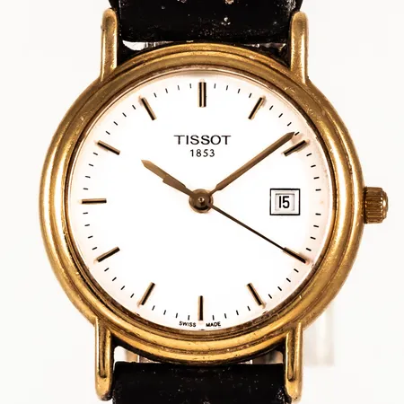 Damur Tissot i 18K guld med brunt läderband. Boett Ø ca 27 mm, safirglas, datum, quartz, gravyr "FÖR NIT OCH REDLIGHET..."  Bruttovikt: 22,3g. Defekt läderband.
