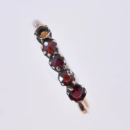 Ring med troligen granater, stl 17½, bredd 2-4 mm, en sten saknas, 18K. Vikt: 1,2 g