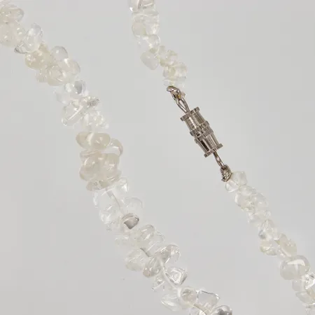 Collier av vita chips-pärlor möjligen bergkristall, längd ca 52cm, doserad bredd ca 5,5-11mm, vitmetall lås.