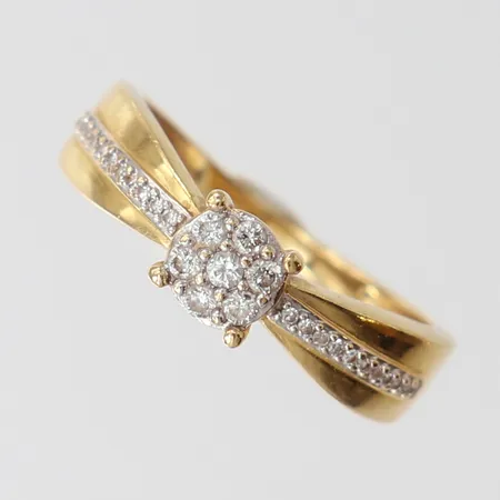 Ring med briljantslipade diamanter 1 x ca 0,02ct, 6 x ca 0,015ct, 8/8-slipade diamanter 22 x ca 0,005ct, stl: 16, bredd 1,5-5mm, GHA, 18K.  Vikt: 2,6 g