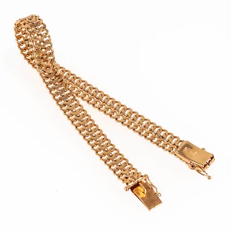 Armband, Fiskbenslänk i 18K guld. Det är 18,7 cm långt, 7,7 mm brett och väger 16,2g. Kistlås. Tillverkat 1965 av Svenska Guldvaruaktiebolaget i Stockholm. Stämplat 18K & kattfot.