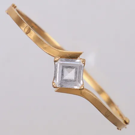 Stelt armband med vit sten, innermått ca 57x53mm, bredd 2,8-16,8mm, bucklor, ostämplat, 18K Vikt: 8,3 g