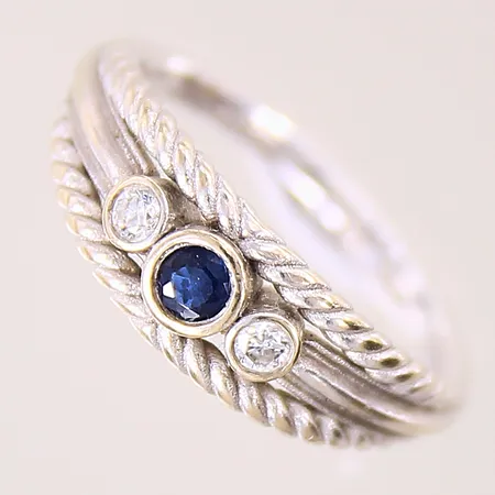 Ring med briljantslipade diamanter ca 2 x ca 0,04ct samt troligen syntetisk blå safir, stl: 17¾, bredd: 2-6,6mm, vitguld, 14K  Vikt: 3,8 g