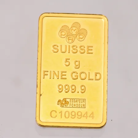 Guldtacka i 24K guld, 999,9/1000, Suisse, 13,2x22,1mm, vikt 5g.