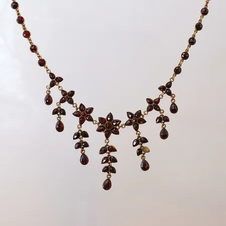 Collier med granater varav en saknas, längd 40,5cm, bredd 4-40mm, troligtvis sent 1800-tal, gulmetall.