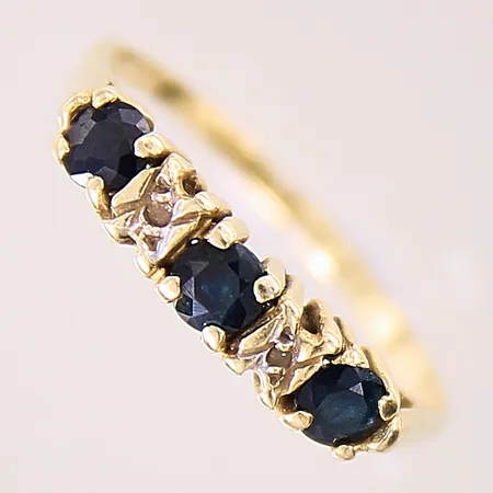 Ring med troligen syntetiska blå safirer, stl: 18, bredd: 1,3-3,4mm, skev, 14K  Vikt: 1,7 g