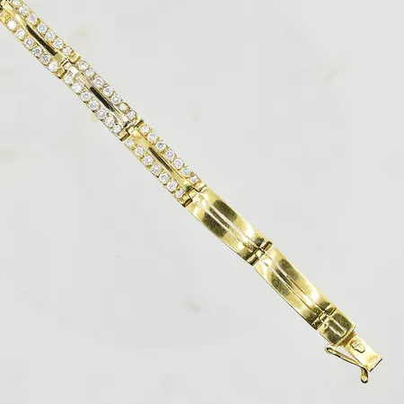 Armband med vita stenar, längd 18½ cm, bredd 7 mm, halvstel modell, en sten saknas, 21K. Vikt: 23,5 g