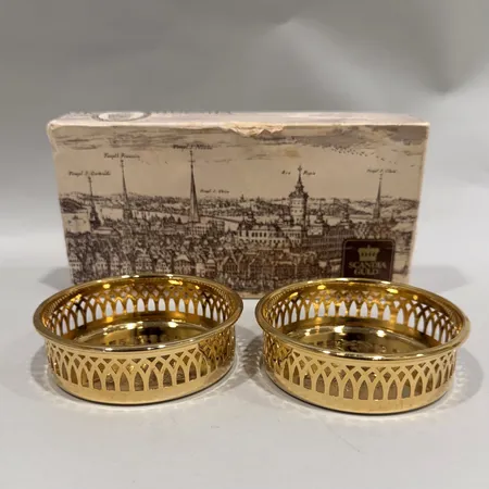 Coasters, Scandia Guld, två stycken, genombruten dekor, Ø10cm, 24K guldplätering, något repiga, bruksslitage, box med slitage Skickas med paket.