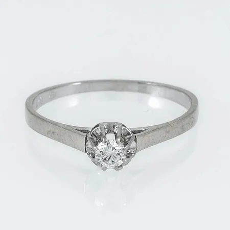 Ring i 18K vitguld med 1 x 0,14ct briljantslipad diamant. Den är i storlek 17½, är 1,2 - 5 mm bred och väger 1,9g. Stenstorlek 0,14ct ingraverad. Stämplad A10 (1975), GFAB, 18K, svensk importstämpel. 