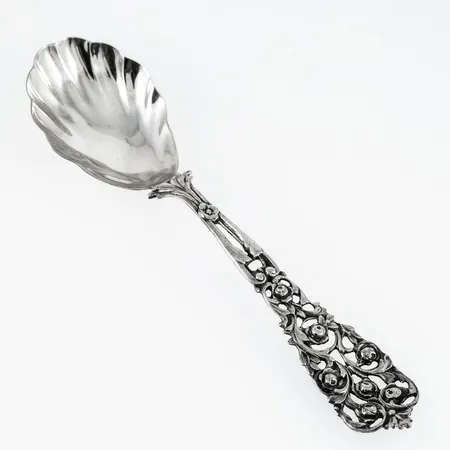 Kompottsked i silver (830/1000), skaft med rosmotiv. Längd 187 mm. Vikt: 42,9g.