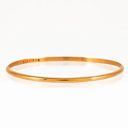 Armring i 18K guld. Innermått c:a 19 cm, 2,7 mm bred och väger 11,7g. Något ojämn i formen, spricka vid stämpel. Tillverkad 1947 av Kjellins AB, Umeå. 18K & kattfot.