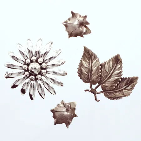 Två broscher, Ø45mm, Ø40mm, ett par örhängen lönnlöv clips, Ø20mm, silver 800/1000 Vikt: 25,3 g